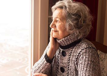 Elderly woman looking out window