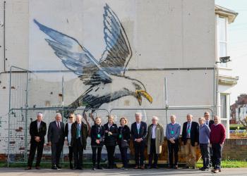 Historic England commissioners in front of the Banksy seagull in Lowestoft