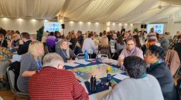 A large number of people at an event inside a marquee