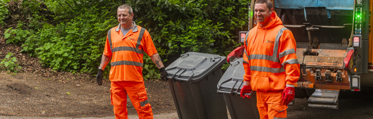 Two men collecting bins next to a bin lorry