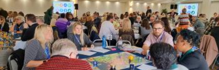 A large number of people at an event inside a marquee