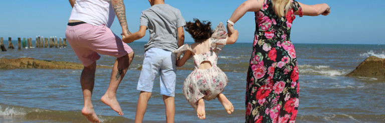 Family jumping by the sea